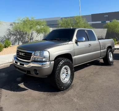 Tan lifted GMC Sierra truck with clean wheels and paint