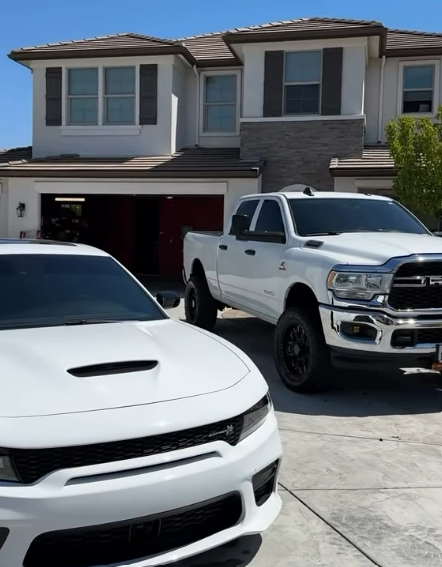 White Dodge Charger and Ram truck parked in a driveway after a detail