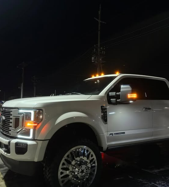 White Ford Super Duty truck gleaming under parking-lot lights