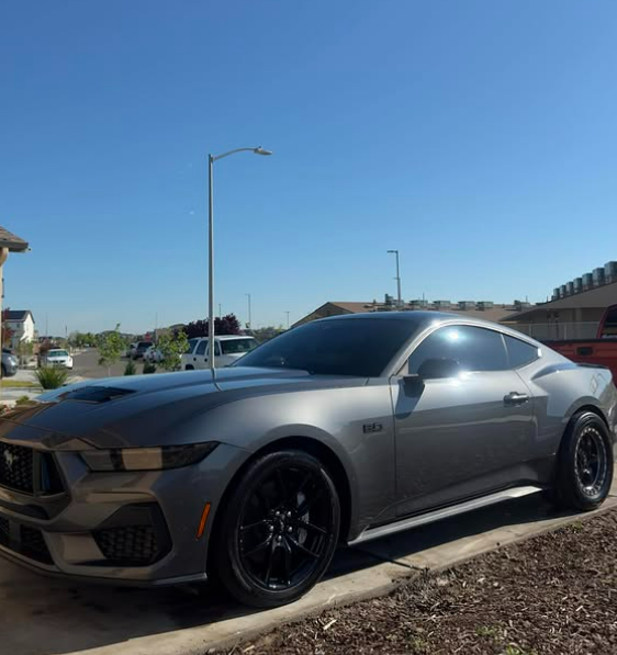 Gray Ford Mustang with glossy paint parked on a suburban street